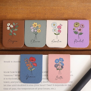 Può includere: Sei segnalibri in pelle, ognuno con un diverso design floreale e un nome. I segnalibri sono in vari colori, tra cui marrone, verde, crema e blu. I nomi Megan, Olivia, Amelia, Rachel, Gracie e Bella sono stampati su ogni segnalibro.