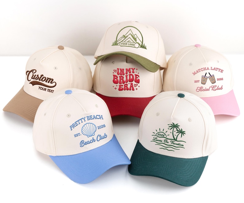 May include: Several baseball caps in shades of beige, red, pink, blue, and green. Each cap has embroidered text and designs, including "Custom," "Pretty Beach," and "Matcha Latte." The caps are displayed on a white background.