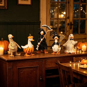 Puede incluir: Un conjunto de cinco figuras decorativas de patos disfrazados para Halloween. Las figuras incluyen un pato momia, un pato dentro de una calabaza, un pato parca con una guadaña, un pato bruja con una escoba y un pato fantasma con pajarita.