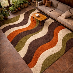 May include: A large, rectangular area rug with a retro design. The rug features wavy stripes in shades of brown, orange, green, and cream. The rug is placed on a tiled floor, and a wooden coffee table and sofa are visible.