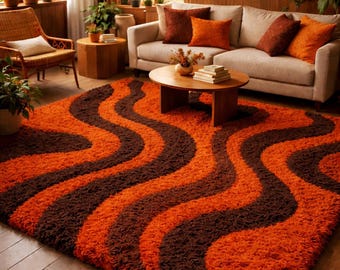 May include: An orange and brown shag rug with a wavy pattern dominates the foreground of a living room. The rug's design features alternating bands of orange and dark brown. The room includes a beige sofa with orange and brown pillows, a wooden coffee table, and a wicker chair.