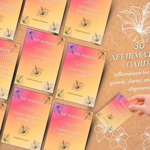 Puede incluir: Un conjunto de 30 tarjetas de afirmación con un fondo degradado rosa, naranja y amarillo. Cada tarjeta presenta un diseño floral y una afirmación positiva. Las tarjetas son para el crecimiento interior y la claridad.