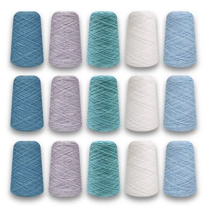 May include: A collection of fifteen spools of yarn in various colors, including shades of blue, teal, lavender, and white. The yarn is tightly wound on conical spools, suitable for knitting or crochet projects.