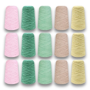 May include: A collection of fifteen spools of yarn in various colors. The colors include pink, green, light green, tan, and yellow. The yarn is tightly wound on conical spools, suitable for knitting or crocheting projects.