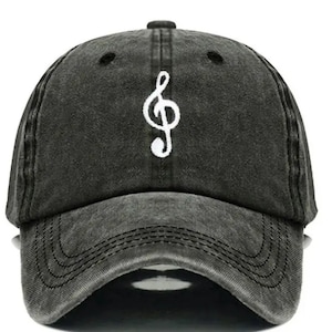May include: A black distressed baseball cap with a white treble clef embroidered on the front.