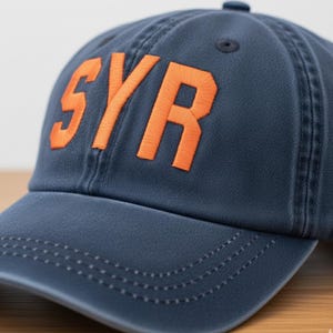 Embroidered SYR Airport Code Baseball Hat - Pigment Dyed Cotton Cap-Pigment dyed blue hat with orange thread