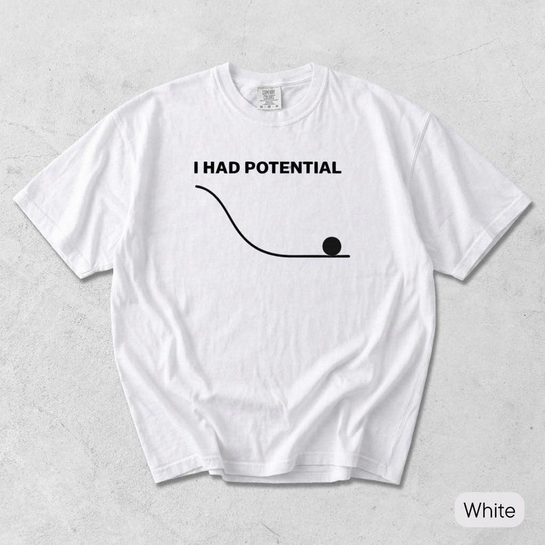 Pode incluir: Uma t-shirt branca de manga curta com uma impress&atilde;o gr&aacute;fica preta. O design inclui o texto I HAD POTENTIAL acima de um desenho de linha de uma rampa curva com um c&iacute;rculo preto s&oacute;lido a descansar no fundo da inclina&ccedil;&atilde;o.