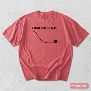 Pode incluir: Uma t-shirt de manga curta na cor melancia com um gr&aacute;fico preto de uma linha curva e um pequeno c&iacute;rculo na parte inferior. Acima do gr&aacute;fico, o texto I HAD POTENTIAL est&aacute; escrito em letras mai&uacute;sculas pretas. Gola redonda.