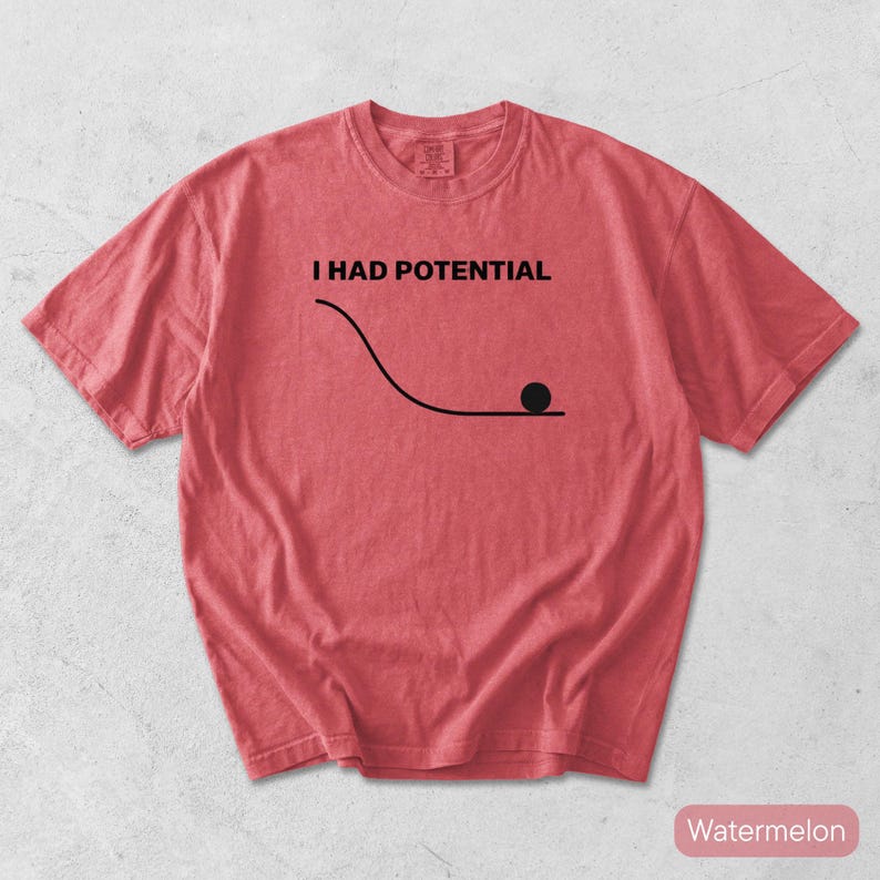 Pode incluir: Uma t-shirt de manga curta na cor melancia com um gr&aacute;fico preto de uma linha curva e um pequeno c&iacute;rculo na parte inferior. Acima do gr&aacute;fico, o texto I HAD POTENTIAL est&aacute; escrito em letras mai&uacute;sculas pretas. Gola redonda.