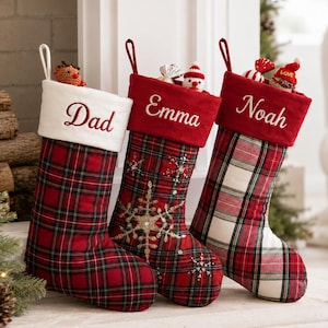 Könnte beinhalten: Drei Weihnachtsstrümpfe mit rot-weißem Schottenkaro. Der erste hat einen weißen Umschlag mit dem Namen Dad. Der zweite ist rot mit einer goldenen Schneeflocke und dem Namen Emma. Der dritte ist rot-weiß kariert mit dem Namen Noah.