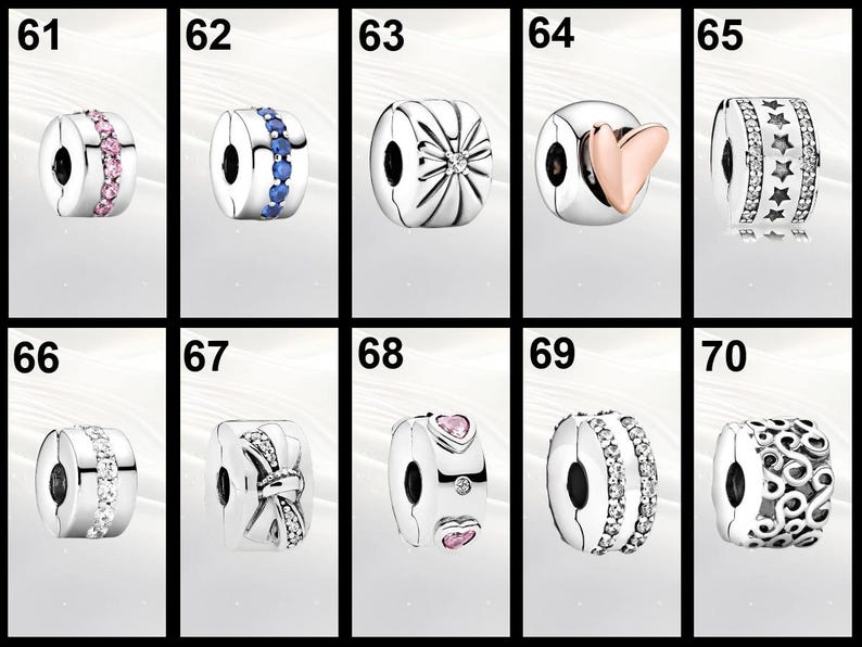 Op de afbeelding: Een verzameling zilverkleurige bedel kralen met diverse ontwerpen. Sommige kralen hebben roze of blauwe edelstenen, terwijl andere hart-, ster-, strik- of bloempatronen hebben. Elke kraal heeft een centraal gat om te rijgen.