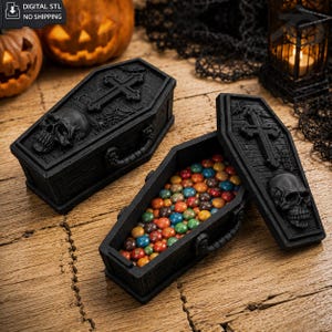 May include: Two black coffin-shaped boxes with textured wood grain, each featuring a raised skull and cross design on the lid. One box is closed, while the other is open and filled with small, multicolored round candies. The text reads DIGITAL STL NO SHIPPING.