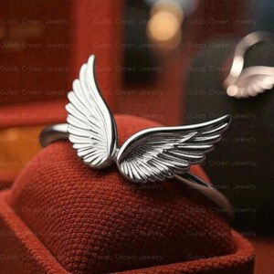 angel wings ring
wing ring silver
sterling silver ring
adjustable wing ring
minimalist ring
symbolic jewelry
dainty silver ring
everyday ring women
open ring design
feather wing ring
gift for her
modern silver ring
handmade style ring