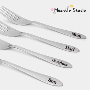 May include: Four stainless steel forks with engraved text. The forks are labelled "Mum", "Dad", "Daughter", and "Son". The forks are arranged diagonally against a light background. The Meantly Studio logo is in the top right corner.