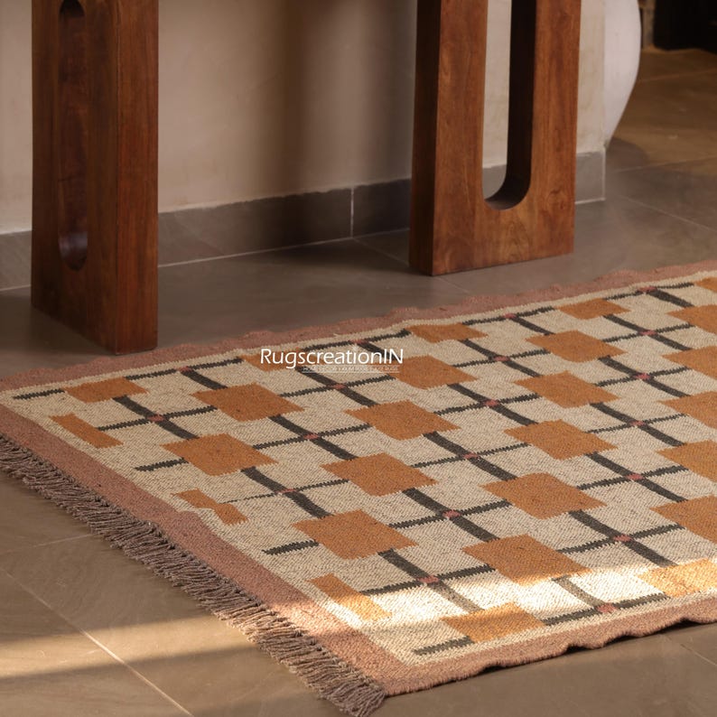 May include: A rectangular rug with a geometric pattern of brown squares and black lines on a beige background. The rug has a pink border and fringe. nursery rug, custom size runner, wool jute rug, navajo pattern rug, rustic modern rug, bedroom area rug, boho floor rug, hallway runner rug, living room area rug, red geometric rug, red handwoven rug, red southwestern rug, red stairs runner, vintage red rug