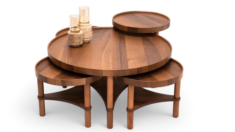May include: A multi-tiered, wooden coffee table with a warm brown finish. The table features a large, round top with several smaller, circular platforms at varying heights. Decorative glass and textured vases sit on the top. The table's legs are cylindrical.