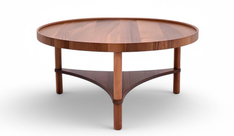 May include: A circular wooden coffee table with a tray-style top and three legs. The table is made of dark brown wood with a lighter brown central support and a triangular shelf. The design is modern and minimalist.