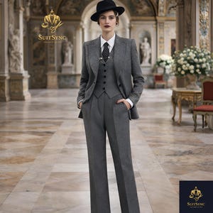 May include: A gray three-piece suit with a black hat. The suit includes a blazer, vest, and high-waisted trousers. The outfit is paired with a white collared shirt and a patterned tie. The image features the "SuitSync" logo.