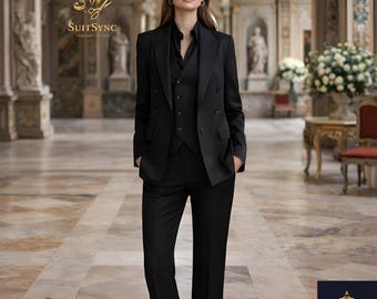 May include: A woman wearing a black three-piece suit, including a double-breasted blazer, vest, and trousers. The suit is tailored and has a classic design. The image includes the text "SuitSync Tailored to You".