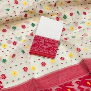 May include: White fabric with a floral pattern in red, yellow, and green. A white fabric square with a red patterned border is on top. The bottom edge has a red border with a floral design.