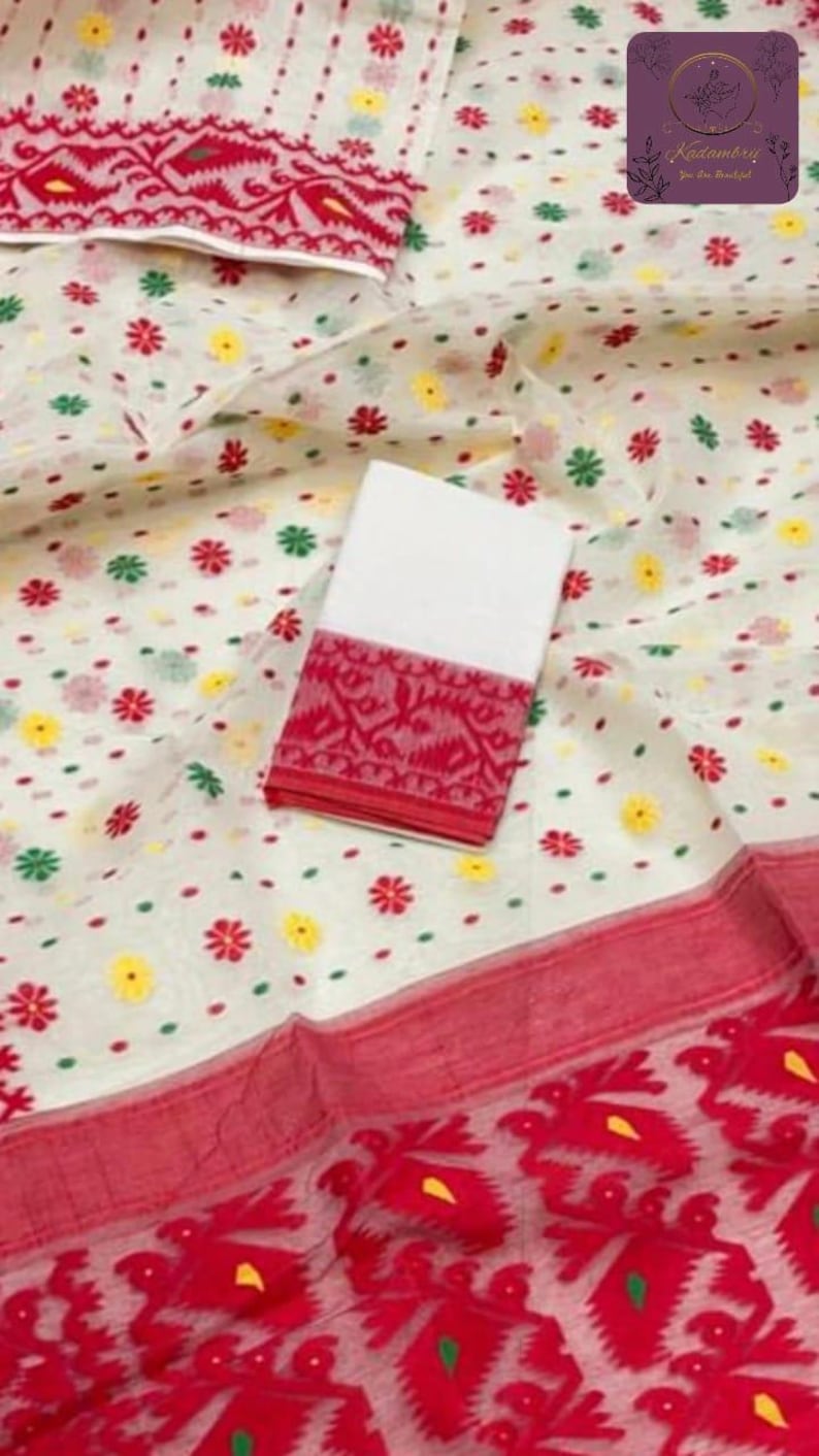 May include: White fabric with a floral pattern in red, yellow, and green. A white fabric square with a red patterned border is on top. The bottom edge has a red border with a floral design.
