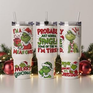 May include: Three white stainless steel tumblers with Grinch-themed designs. Each tumbler features a different Grinch illustration and text: "I'M A MEAN ONE", "PROBABLY JUST GONNA JINGLE", and "DRINK UP GRINCHES IT'S CHRISTMAS".