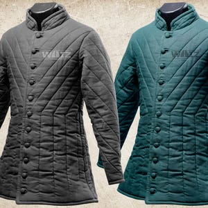 Puede incluir: Dos chaquetas acolchadas, una gris antracita y otra verde azulado, presentadas juntas. Cada chaqueta presenta un cuello alto, cierre de botones y un diseño de rombos. Las chaquetas de manga larga tienen un corte entallado, adecuado para recreaciones históricas o disfraces.