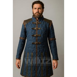 May include: A blue quilted coat with brown leather accents and three buckle closures. The coat features a high collar, shoulder pads, and decorative stitching. The coat has a diamond pattern and is a medieval style.