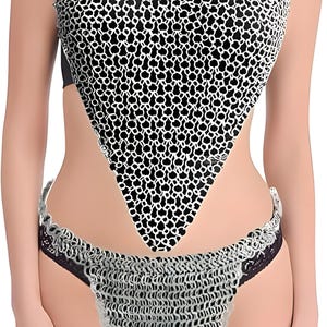 May include: A halter top and bottom set with a chainmail design. The top is a V-neck style with a black and white pattern. The bottom is a matching chainmail design with black lace trim.