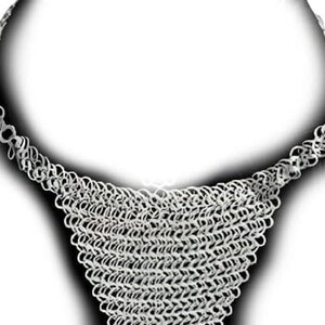 May include: A silver-colored chainmail necklace. The necklace features a wide, woven bib design that tapers to a chain. The chainmail is made of small, interlocking rings, creating a textured, metallic appearance. The necklace is displayed against a white background.