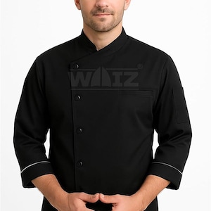 Pode incluir: Casaco de chef preto com gola mandarim, três botões e um bolso no peito. As mangas são de três quartos com acabamento branco. O logótipo "WAIZ" é visível no peito.