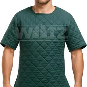 May include: Dark green quilted short-sleeve shirt. The shirt has a diamond pattern and a rounded neckline. The shirt is a solid color and appears to be made of a padded material. The shirt has the letters "WAIZ" printed on the front.