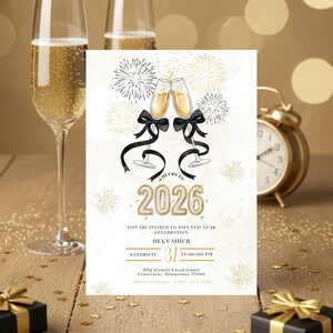 Puede incluir: Tarjeta de invitación de Nochevieja con copas de champán, fuegos artificiales y el año 2026. La tarjeta presenta lazos negros, detalles dorados y detalles del evento. Un despertador dorado y una caja de regalo están en el fondo.