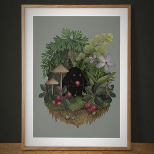 May include: A framed art print featuring a dark, silhouetted creature with glowing red eyes holding a red berry, surrounded by green foliage, ferns, light purple flowers, mushrooms, and red berries on a floating patch of earth with a gray background.