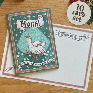May include: A set of 10 Christmas cards with a whimsical goose design. The cards feature a green border and the text "Honk!" and "The herald goose both sing." The accompanying envelope reads "Peace on Earth."