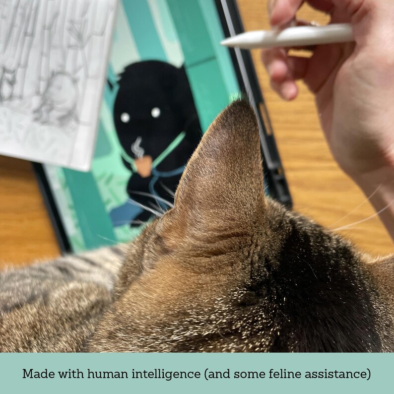 May include: A tabby cat's ear and head are in the foreground. A digital illustration of a black figure with a coffee cup is on a tablet. A hand holds a stylus. Text at the bottom reads: Made with human intelligence (and some feline assistance).