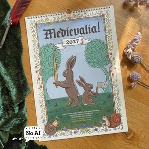 May include: A 2027 wall calendar titled Medievalia! featuring an illustration of two brown rabbits, one holding a sword and the other a flag, surrounded by trees, snails, and floral borders. The text reads Medievalia! 2027, Killer bunnies, angry snails & other weird wonders, Inspired by medieval marginalia & illuminated manuscripts, by littleclyde illustration.