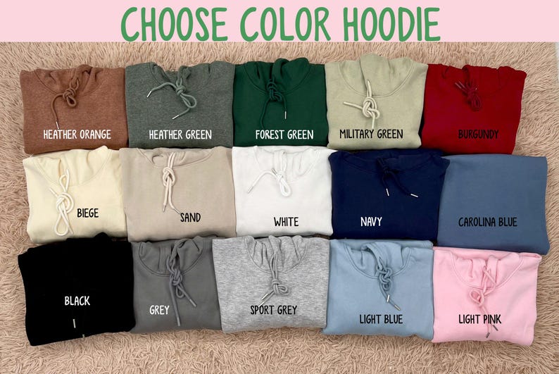 May include: A selection of folded hoodies in various colors, including heather orange, forest green, and navy. The text "CHOOSE COLOR HOODIE" is at the top. Each hoodie has a drawstring and is labeled with its color name, such as "Black" and "Light Pink".