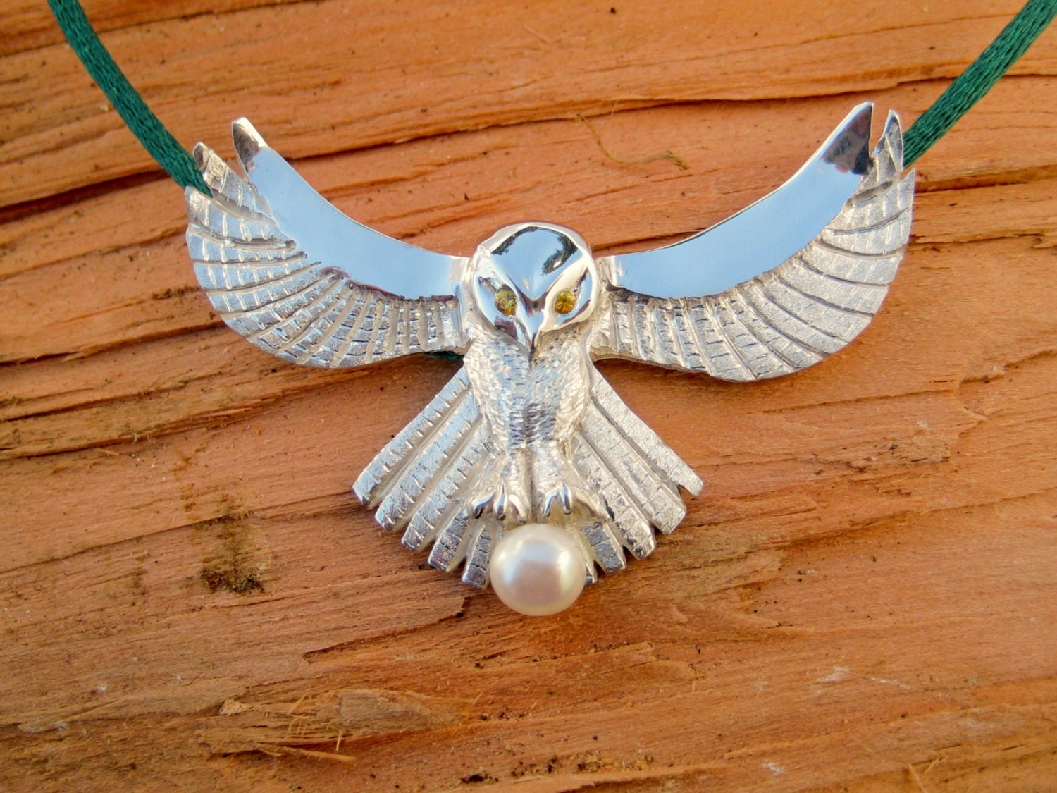A "Fly me to the moon..." Owl pendant featuring gem eyes and pearl "catch" in th