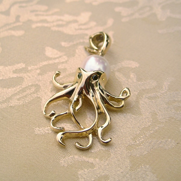 Colgante de pulpo en oro amarillo de 14 kt con cuerpo de perla y ojos de diamante negro.