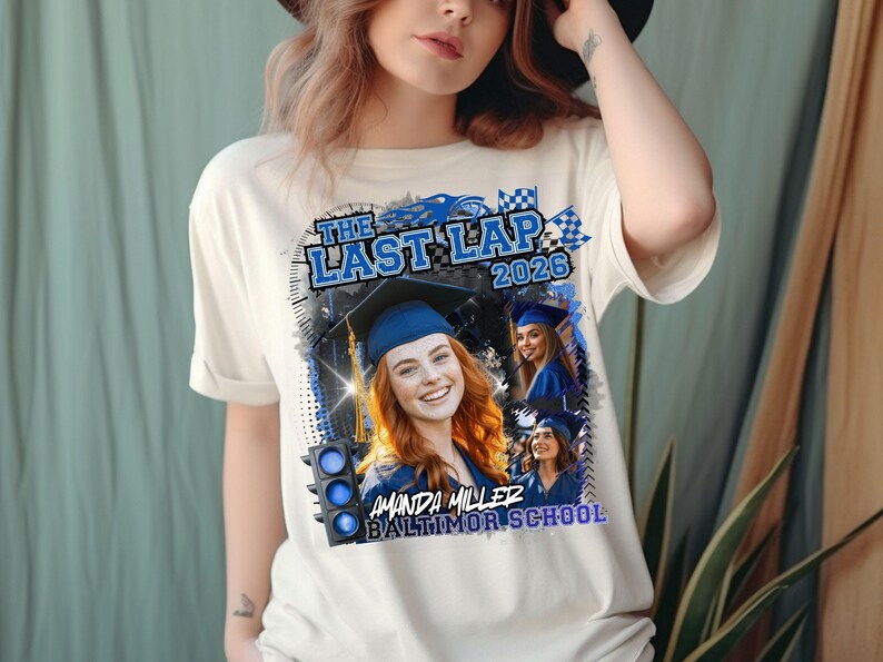 May include: A cream-colored t-shirt featuring a graphic print with the text THE LAST LAP 2026, AMANDA MILLER, and BALTIMOR SCHOOL. The design includes a blue traffic light, checkered flags, and three photographs of a graduate in a blue cap and gown.