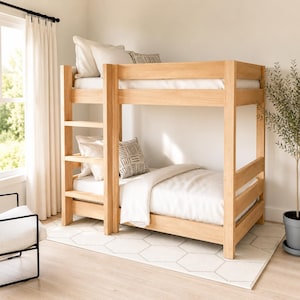 May include: A light-toned wooden bunk bed featuring a built-in ladder on the left side. The bed is dressed with white bedding and includes two white pillows and one small square pillow with a black and white geometric pattern on each level.