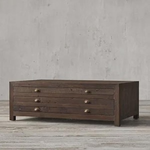 Könnte beinhalten: Ein rechteckiger, dunkelbrauner Couchtisch aus Holz mit drei Schubladen. Jede Schublade hat einen halbmondförmigen Griff in Messingfarbe. Der Tisch ist 152 cm lang, 51 cm breit und 46 cm hoch.