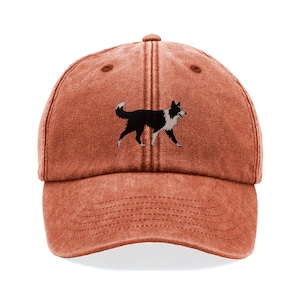May include: A terracotta-coloured baseball cap with an embroidered black and white Border Collie dog. The cap has a curved peak and a six-panel design, with a top button and adjustable strap.