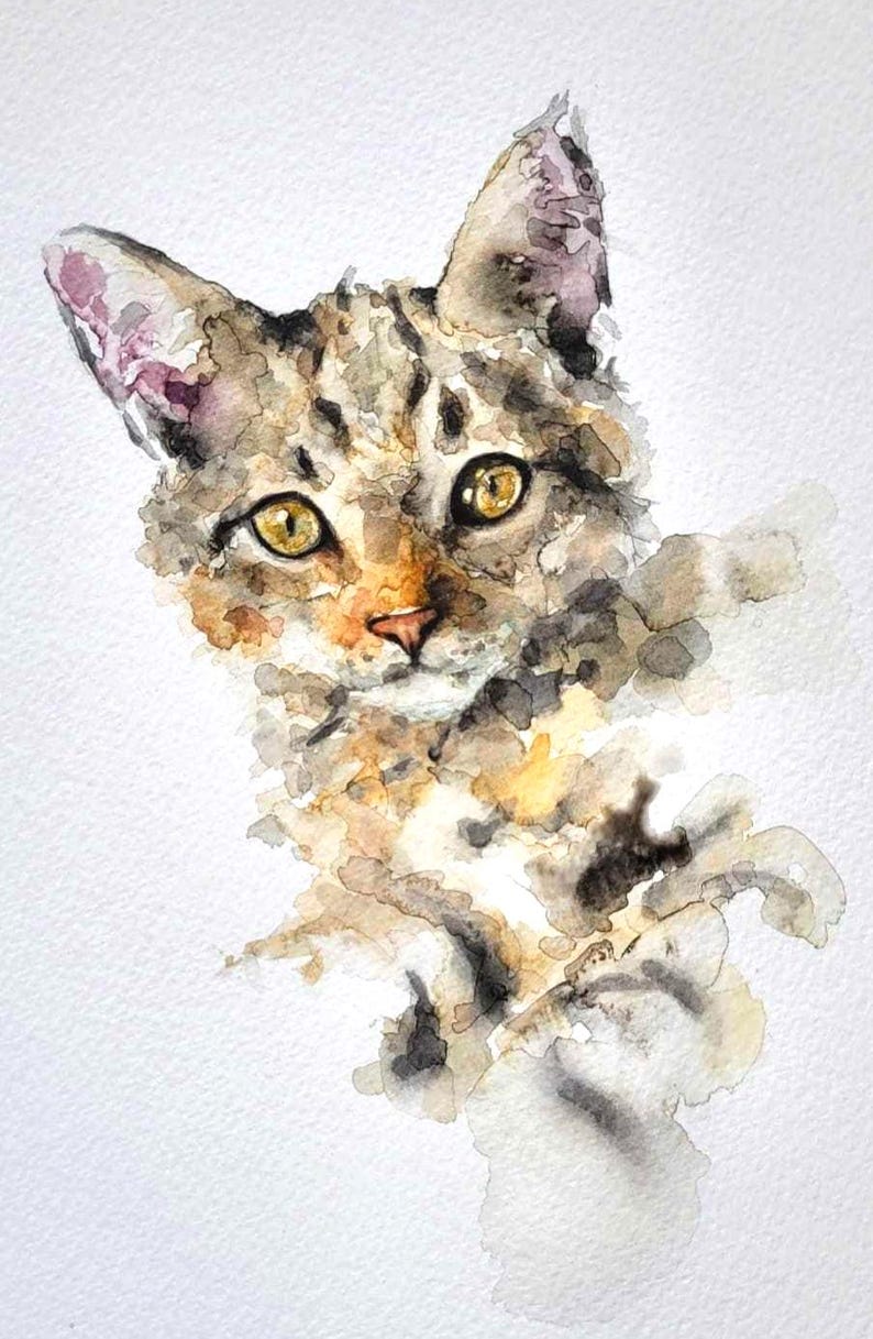 May include: Watercolor painting of a cat's face. The cat has yellow eyes, a pink nose, and a coat of brown, gray, and tan colors. The artwork is on a white background, with the cat's form rendered in loose, expressive brushstrokes.