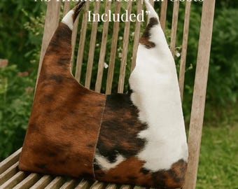 May include: A cowhide shoulder bag with a black leather strap. The bag features a patchwork design with brown, white, and black fur. The text on the bag says "No Hidden Fees | All Costs Included".
