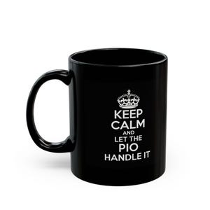 May include: Black ceramic coffee mug with a white crown graphic and the text "KEEP CALM AND LET THE PIO HANDLE IT". The mug has a curved handle and a glossy finish. A great gift for any occasion.