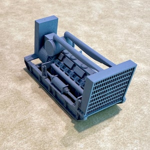 May include: A gray model of a large industrial engine with a detailed design. The engine has a large fan on the side and a series of cylinders.