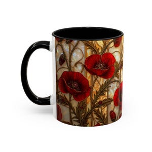Puede incluir: Taza de cerámica blanca con asa e interior negros. La taza presenta un vibrante diseño floral de amapolas rojas con hojas verdes sobre un fondo dorado y crema. El diseño envuelve la taza.