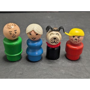 May include: Four wooden peg figures including a person with brown hair in a green base, a person with blonde hair in a blue base, a black and white dog with a red collar, and a person with a yellow cap and red base with painted facial features.